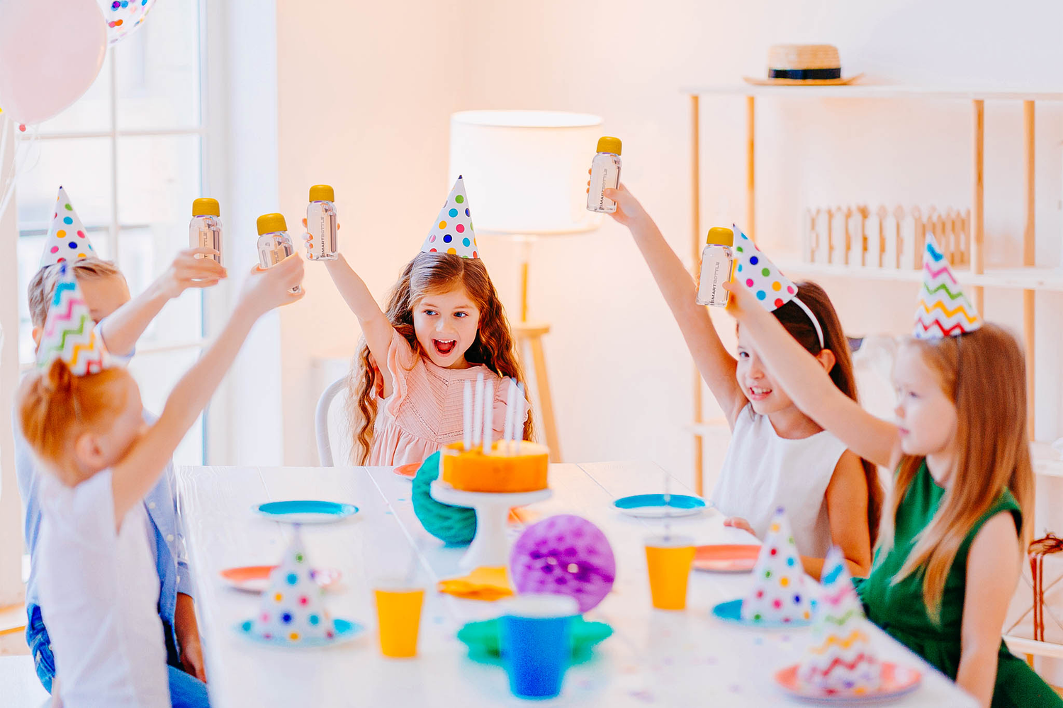 Kids having a party and holding their Smartbottle minis up high